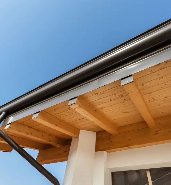 Dark gutter along a roof edge above a wooden porch ceiling