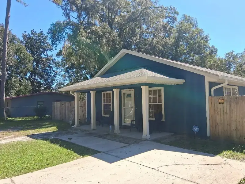 Blue home with finished white gutters and downspouts