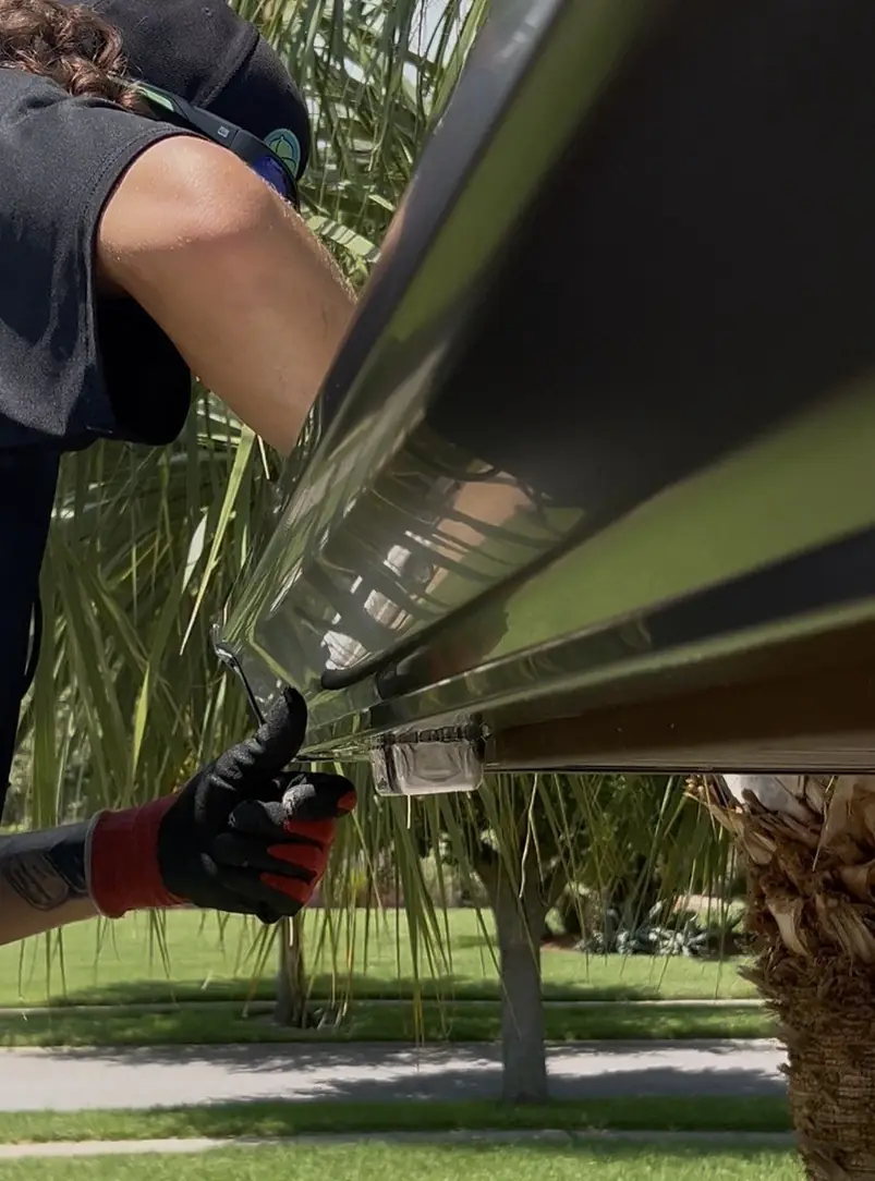 Installer fitting a gutter guard onto a new seamless gutter