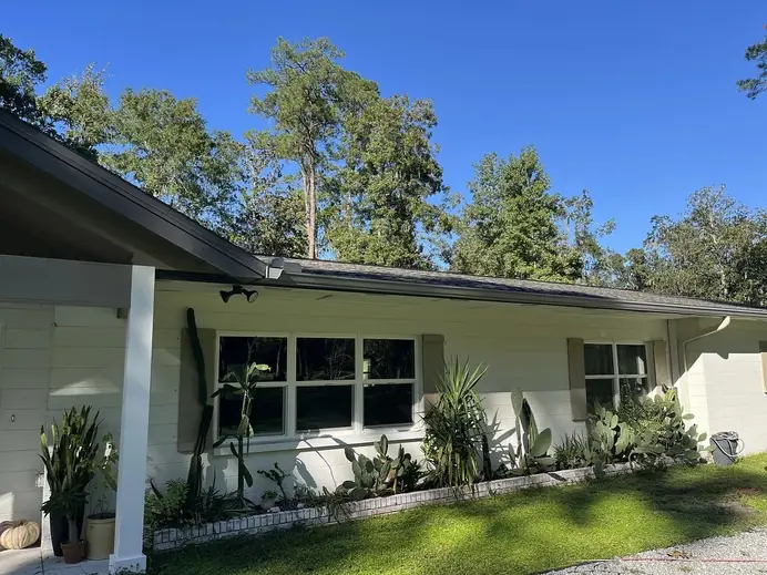 Single-story home with white seamless gutters and a downspout at the porch post