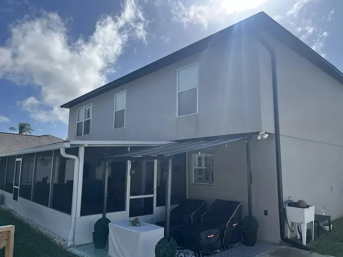 Two-story home with white seamless gutters and downspouts above a screened porch