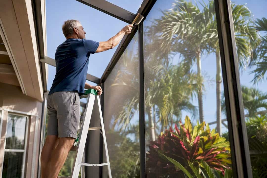 Homeowner cleaning pool cage gutter gently