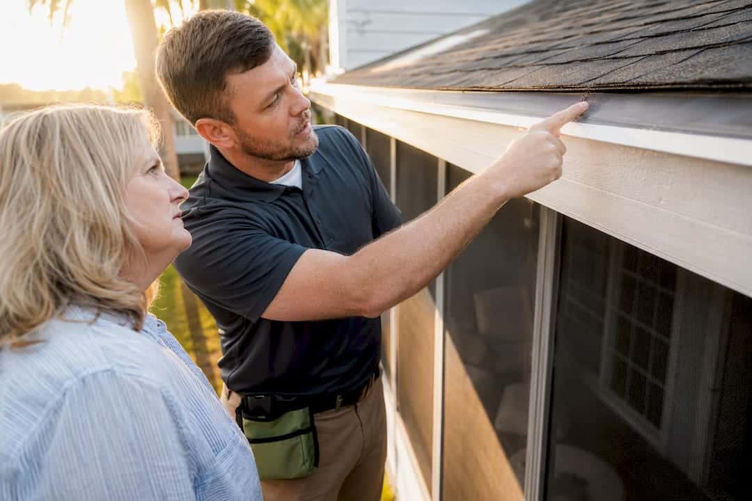 Homeowner inspecting gutter guard installation