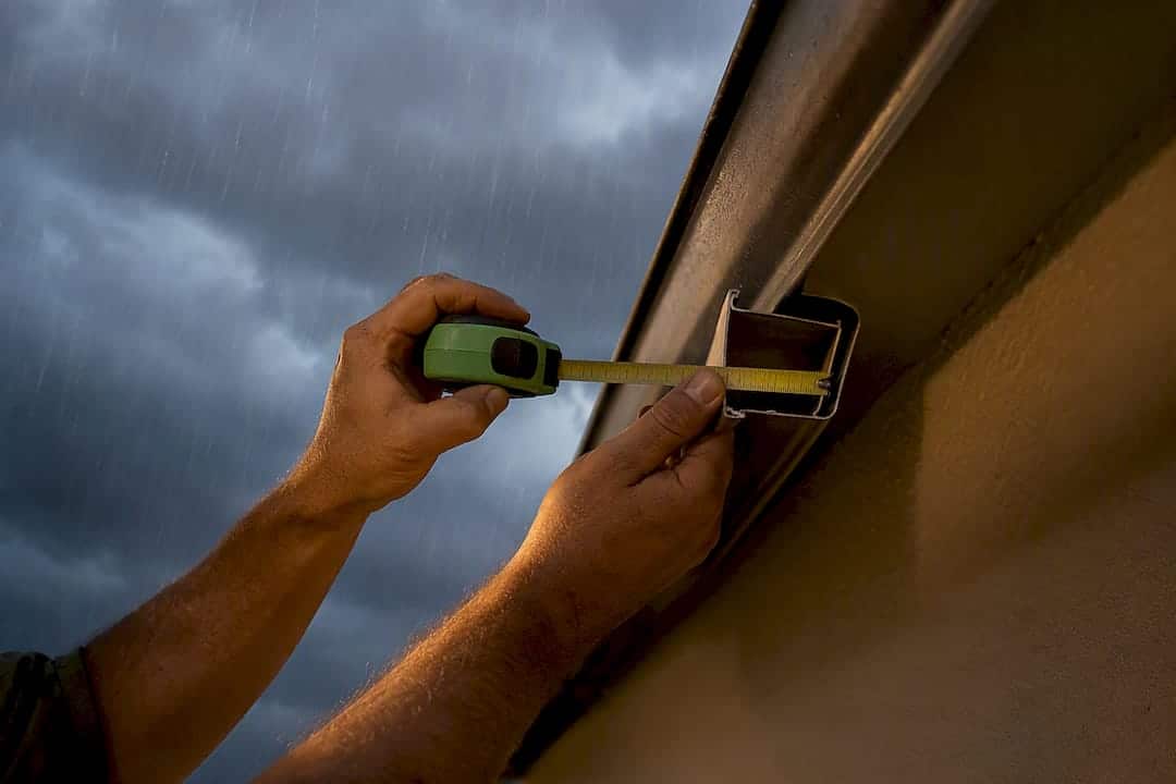 Technician measuring gutter size before installation
